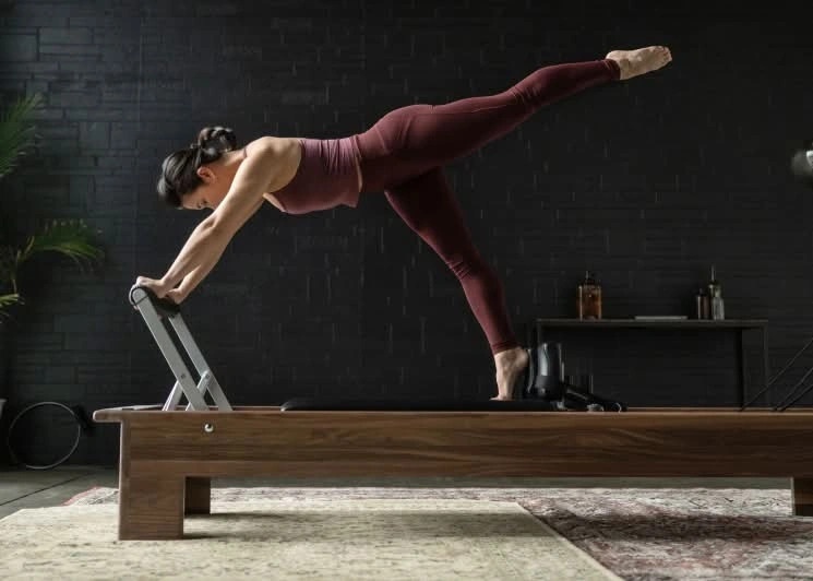 woman on wood reformer